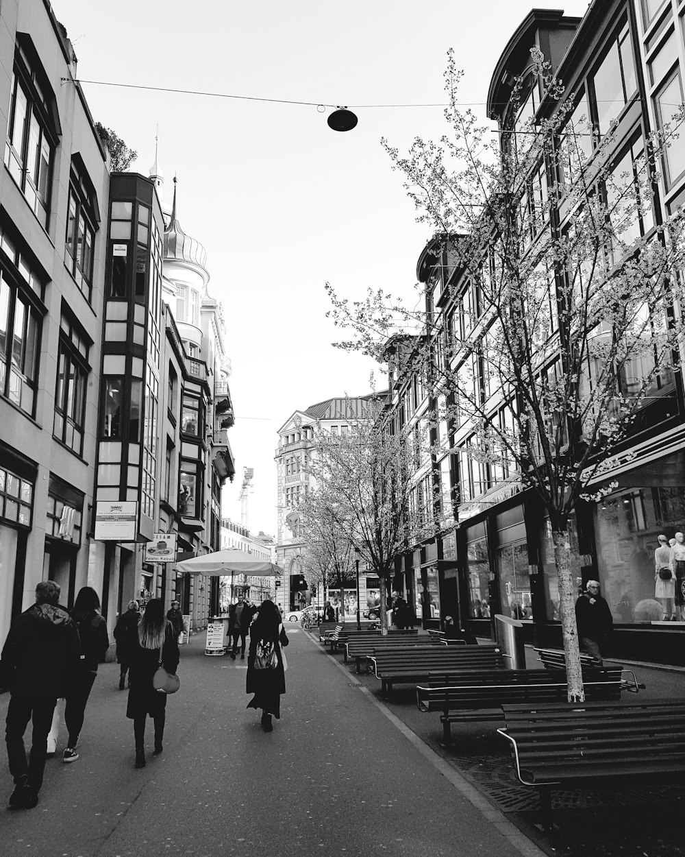 foto em tons de cinza de pessoas andando na rua