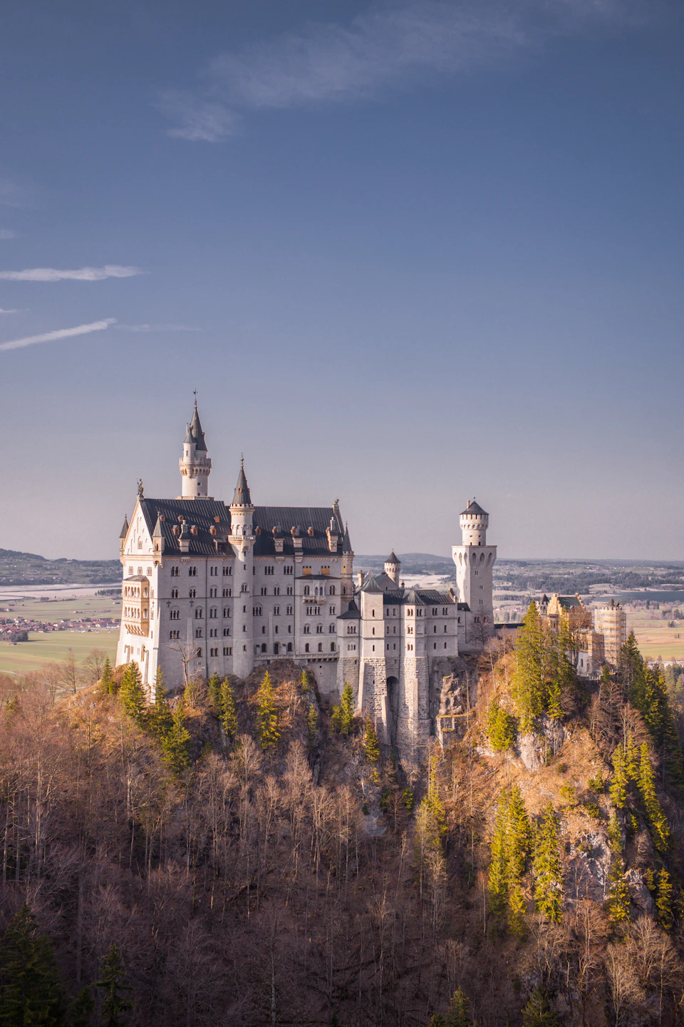 Majestic white stone castle perched on a cliff overlooking a valley below landscape