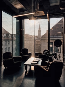 vacant sofa chairs beside glass window
