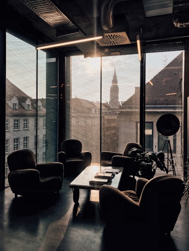 vacant sofa chairs beside glass window