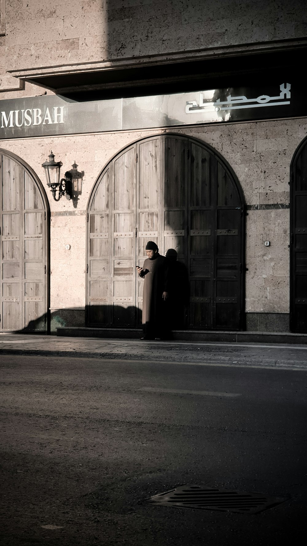 man standing in front of Musbah arch doorway