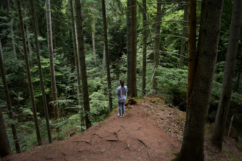 woman standing on cliff under trees