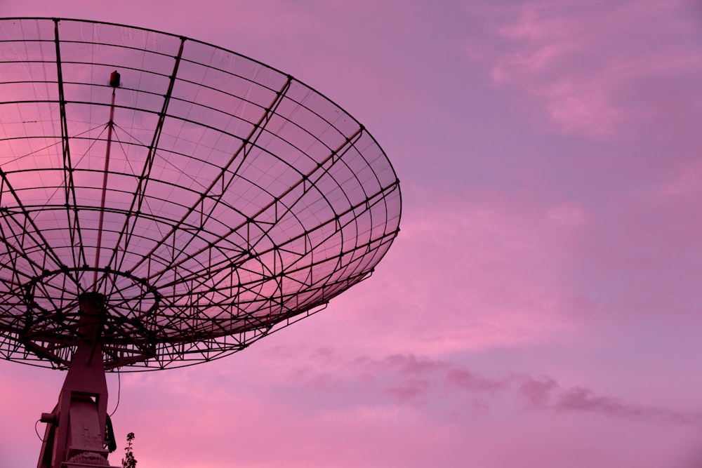 Closeup Of Microwave Dish On High Antenna Tower And Blue Sky