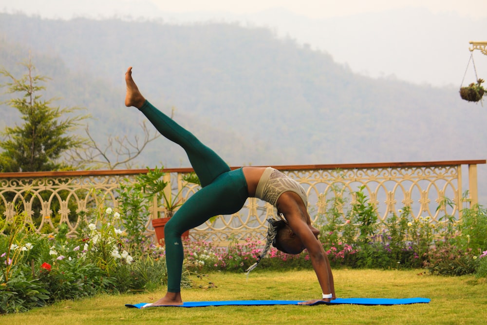 Frau in blaugrünen Leggings posiert Yoga