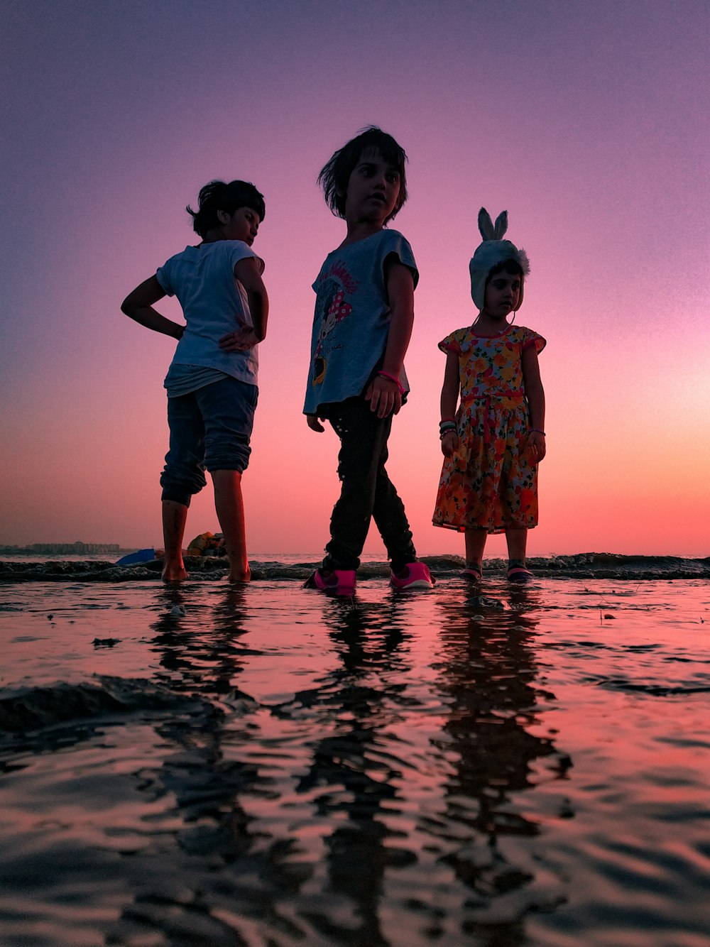 Tres niños en la playa durante la hora dorada