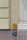Wall-mounted utility markers with detailed numerical information related to gas and water lines. The yellow sign at the top indicates gas, displaying numbers '10.5' and '0.4'. Below it, a blue sign labeled 'Wasser' provides the figures '0.41' and '2.5'. The markers are affixed to a wall with muted tones of cream and light purple, next to architectural molding.