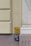 Wall-mounted utility markers with detailed numerical information related to gas and water lines. The yellow sign at the top indicates gas, displaying numbers '10.5' and '0.4'. Below it, a blue sign labeled 'Wasser' provides the figures '0.41' and '2.5'. The markers are affixed to a wall with muted tones of cream and light purple, next to architectural molding.