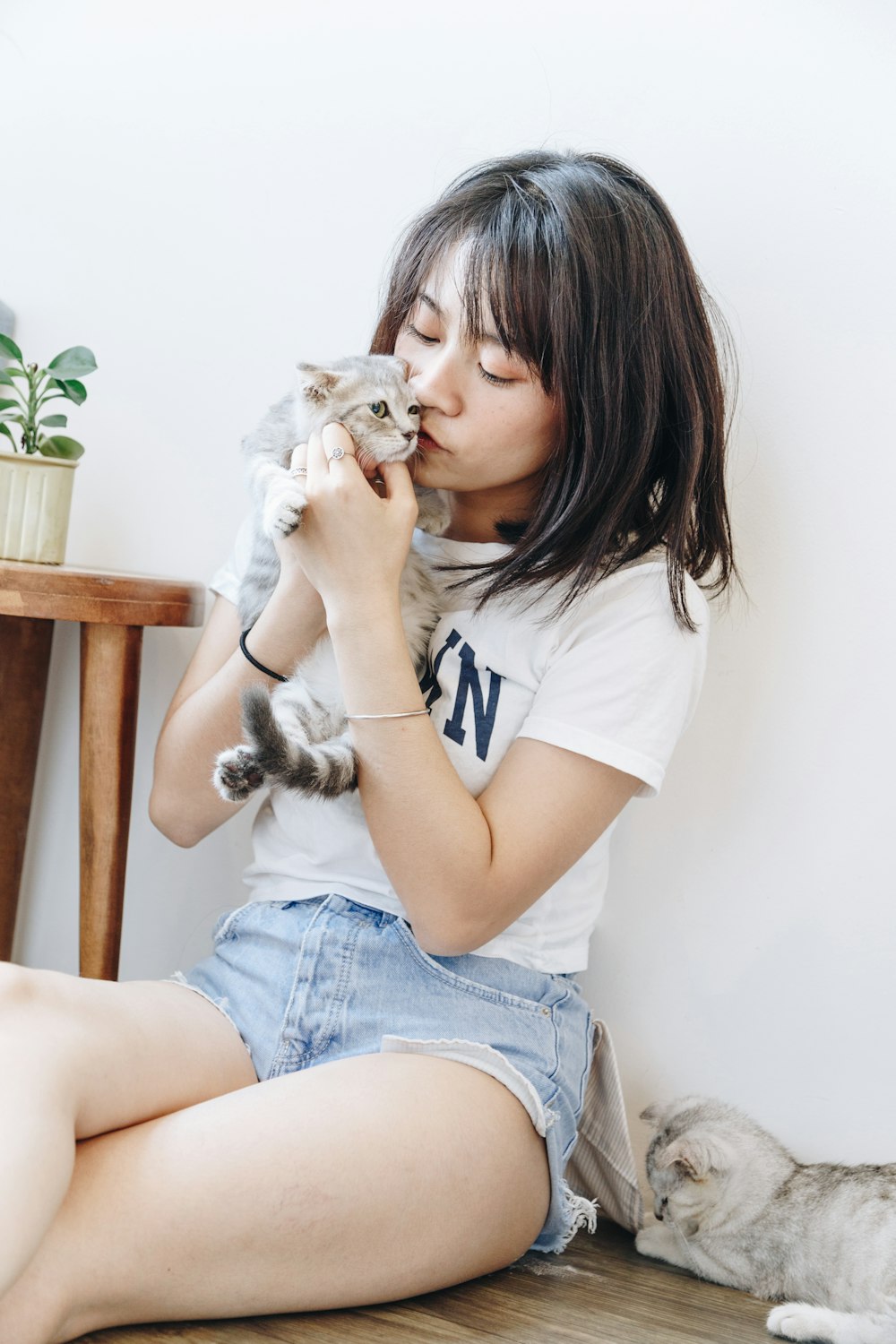 woman sitting and kissing kitten