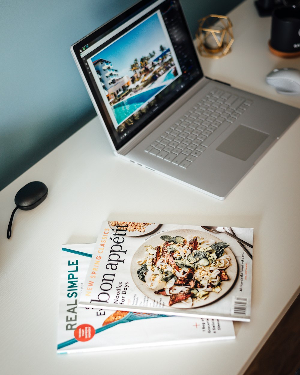 MacBook Pro beside magazines