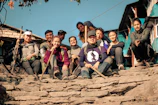 A group of friends in Lumina Apparel activewear laughing and sitting on city steps during golden hour.