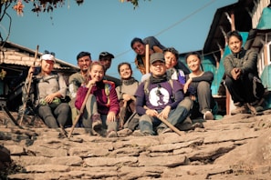 A group of Nepali students smiling and chatting on the steps near the Sydney Harbour Bridge.