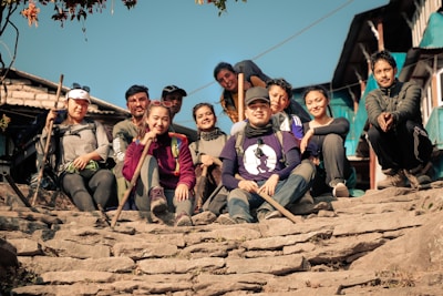 A group of friends in Lumina Apparel activewear laughing and sitting on city steps during golden hour.