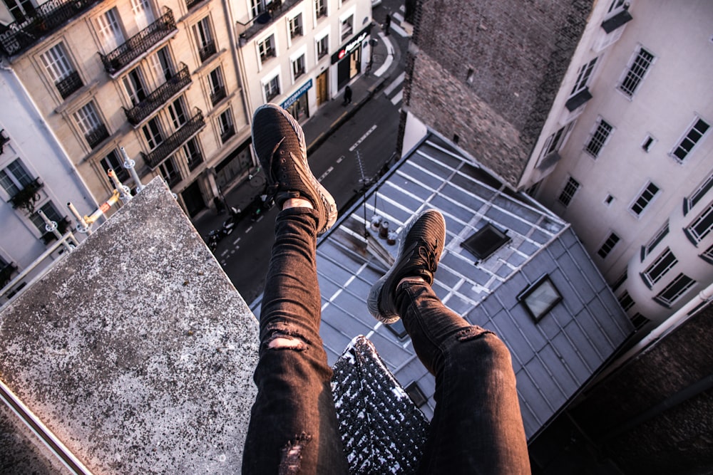 person sitting above building edge