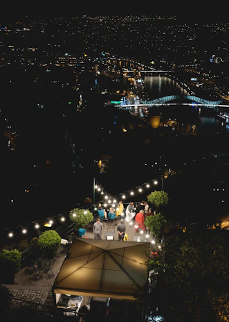 A rooftop venue overlooking city lights, perfect for intimate evening gatherings.