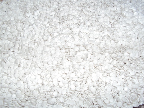 a close up of a pile of white buttons