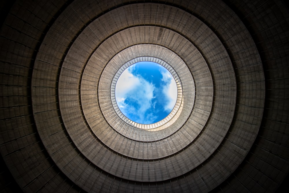 white clouds seen through the hole of brown building