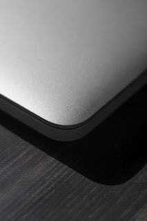 Close-up of a sleek new tech gadget on a wooden desk with soft natural lighting.