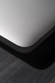 Close-up of a sleek new tech gadget on a wooden desk with soft natural lighting.
