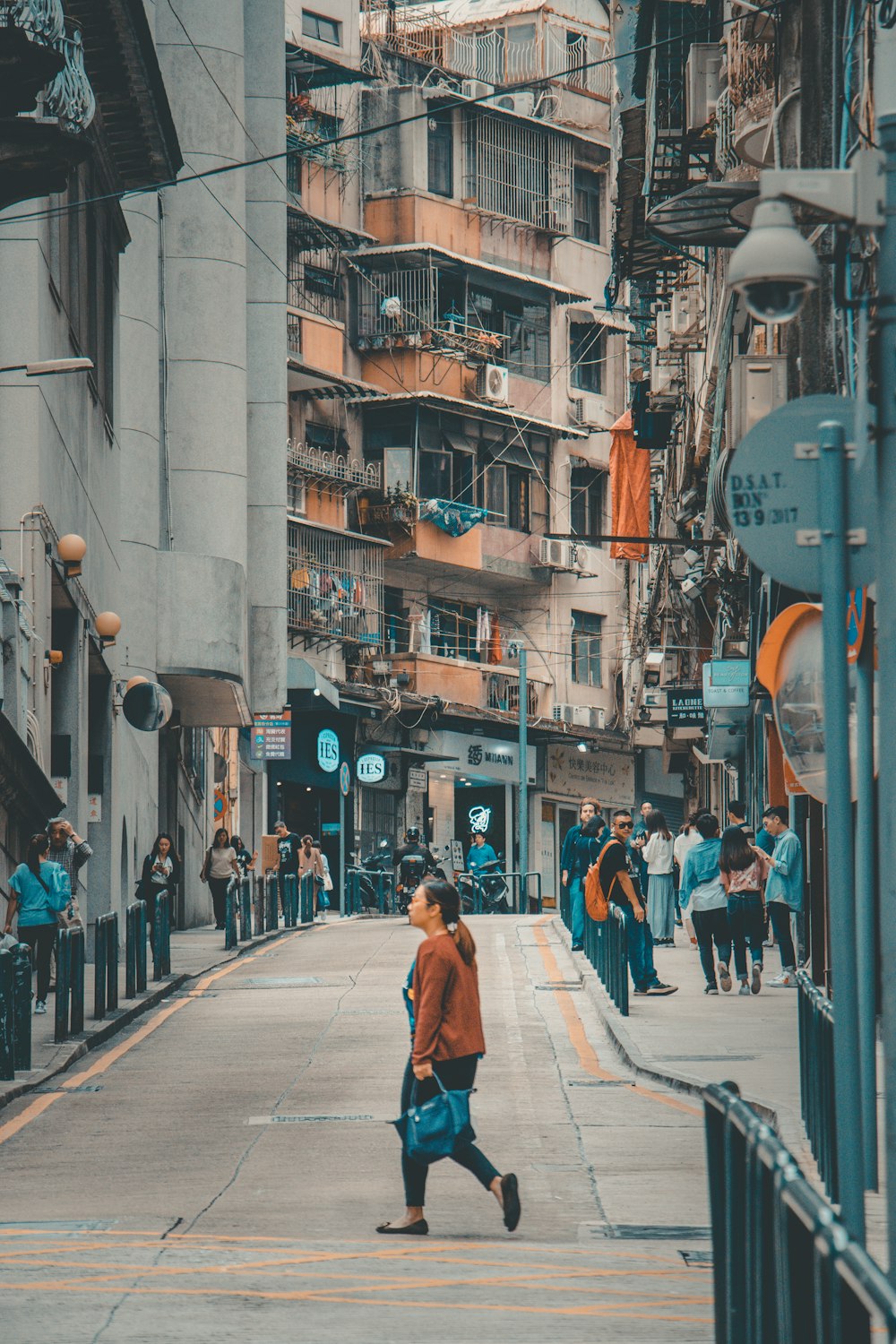 a man walking down a street next to tall buildings