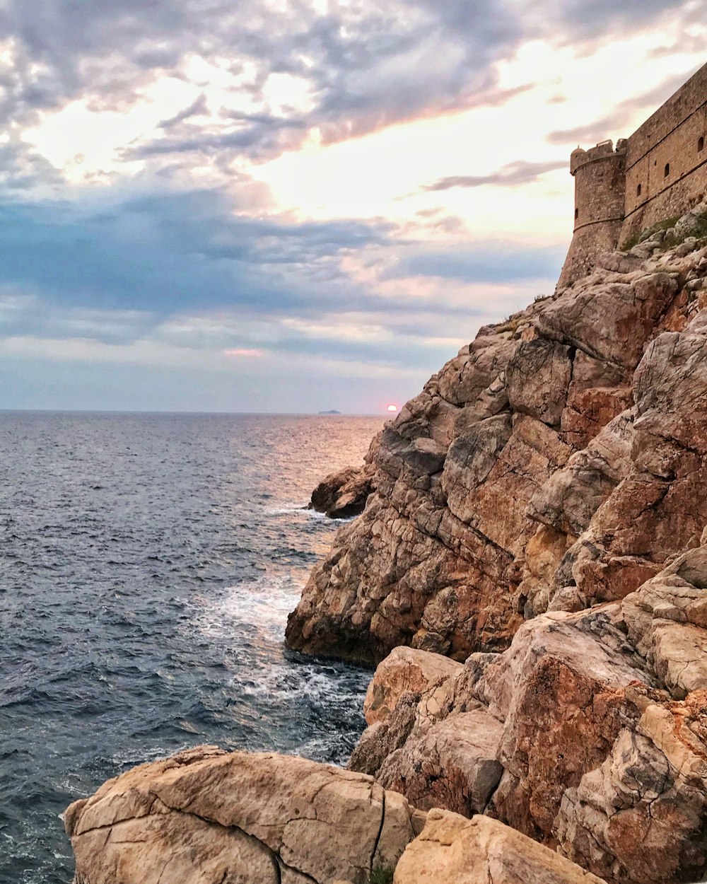 brown cliff beside body of water