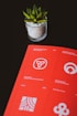 a red book sitting on top of a table next to a potted plant