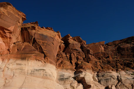 A lively networking event with members exchanging ideas against a backdrop of red sandstone cliffs.
