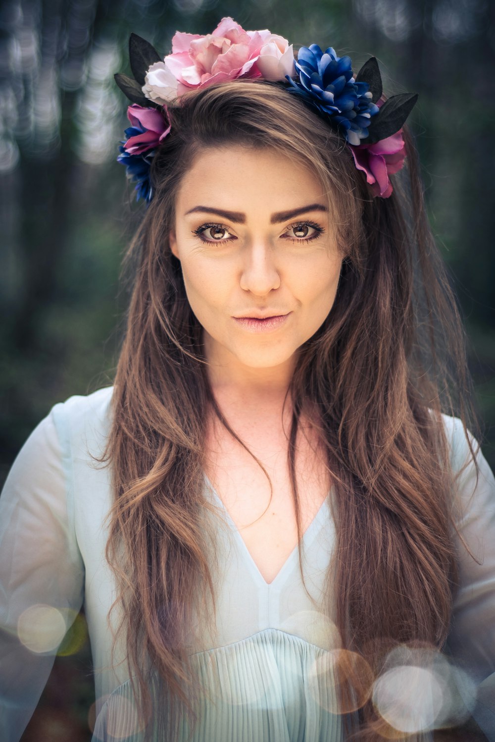 woman wearing teal dress with floral headdress