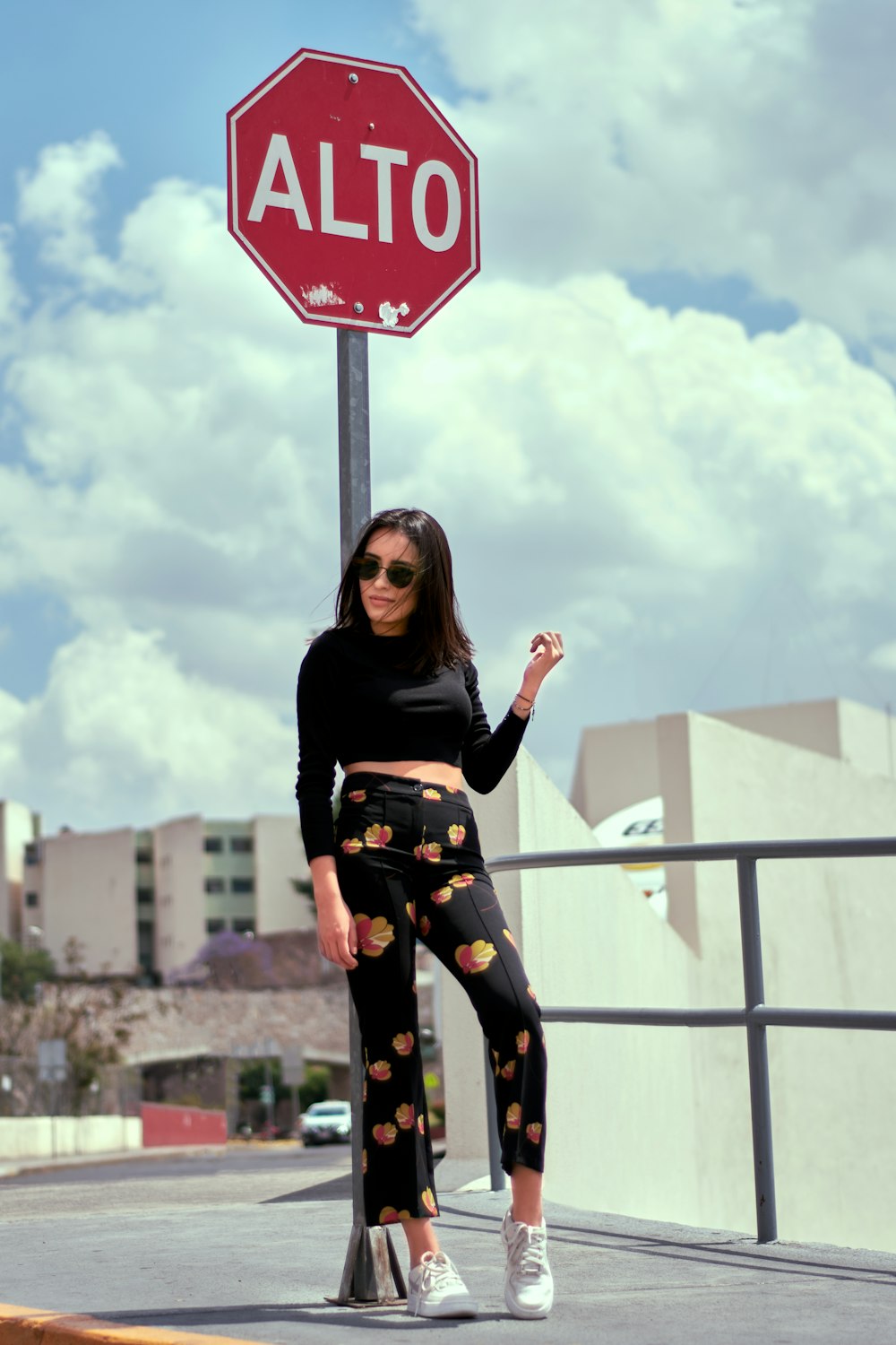 woman standing beside red and white Alto signage during daytime