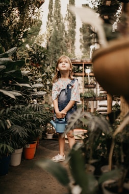 girl surrounded by flowers during daytime