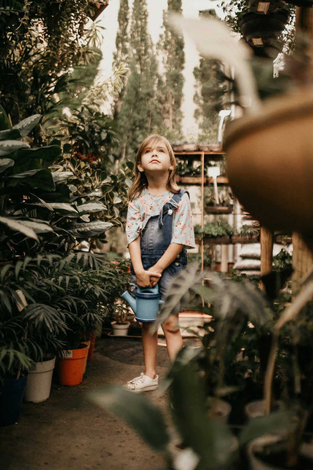 girl surrounded by flowers during daytime