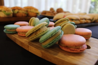 A variety of colorful macarons arranged neatly on a rustic wooden table.
