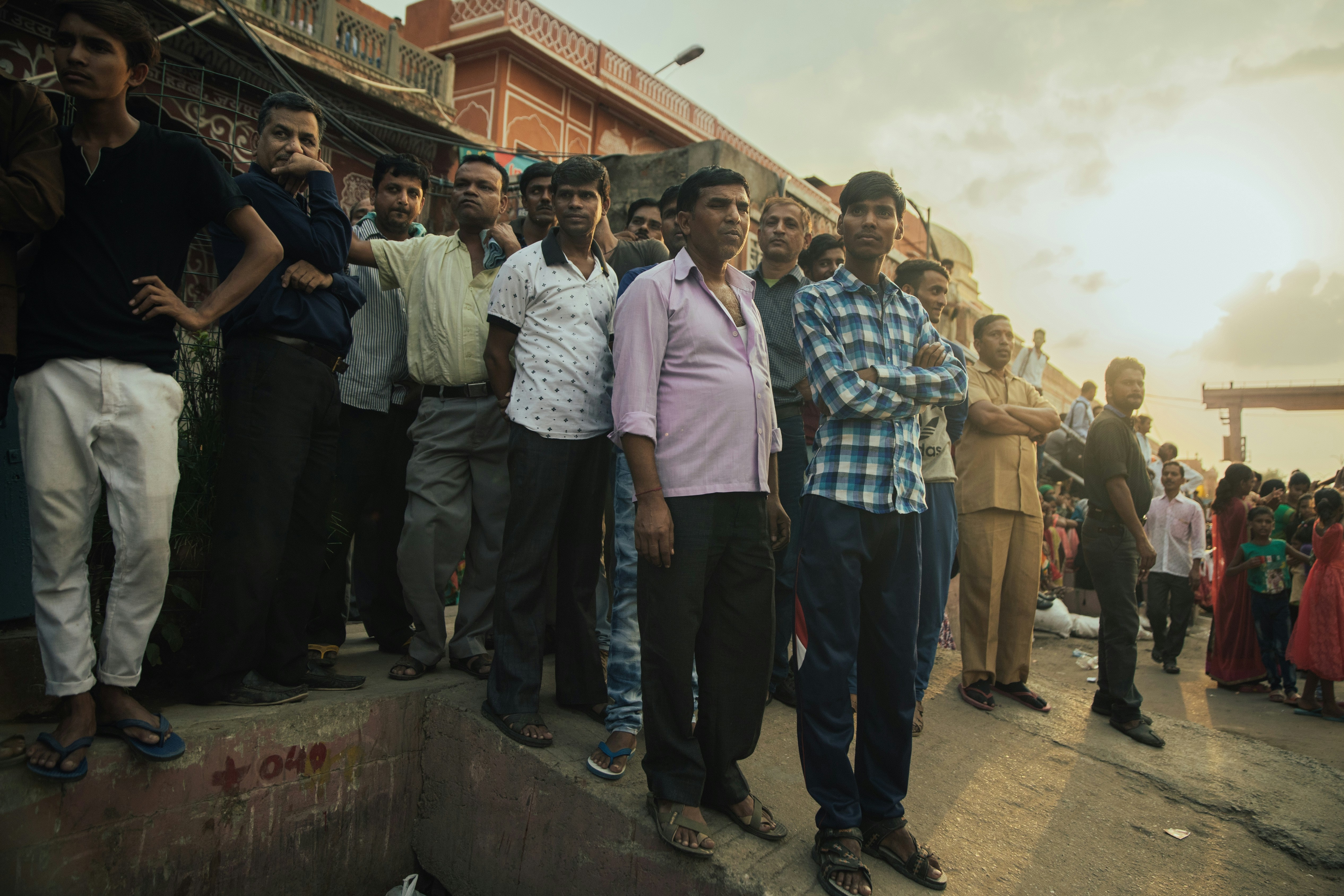 A vibrant, futuristic CGI rendering of a Vande Bharat Sleeper train speeding through a lush green landscape at dawn, with a silhouette of a city skyline in the background.