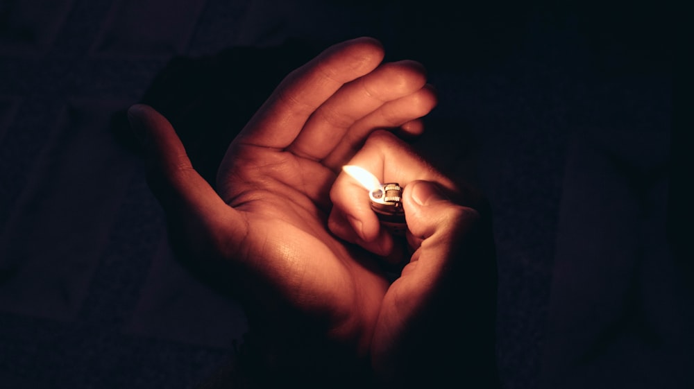 person holding a lighted lighter