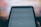 A close-up of a smartphone screen displaying a settings and privacy menu. The text appears slightly blurred, with options like settings, privacy shortcuts, and terms and policies visible. The background is out of focus, creating a contrast with the darker foreground.