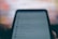 A close-up of a smartphone screen displaying a settings and privacy menu. The text appears slightly blurred, with options like settings, privacy shortcuts, and terms and policies visible. The background is out of focus, creating a contrast with the darker foreground.