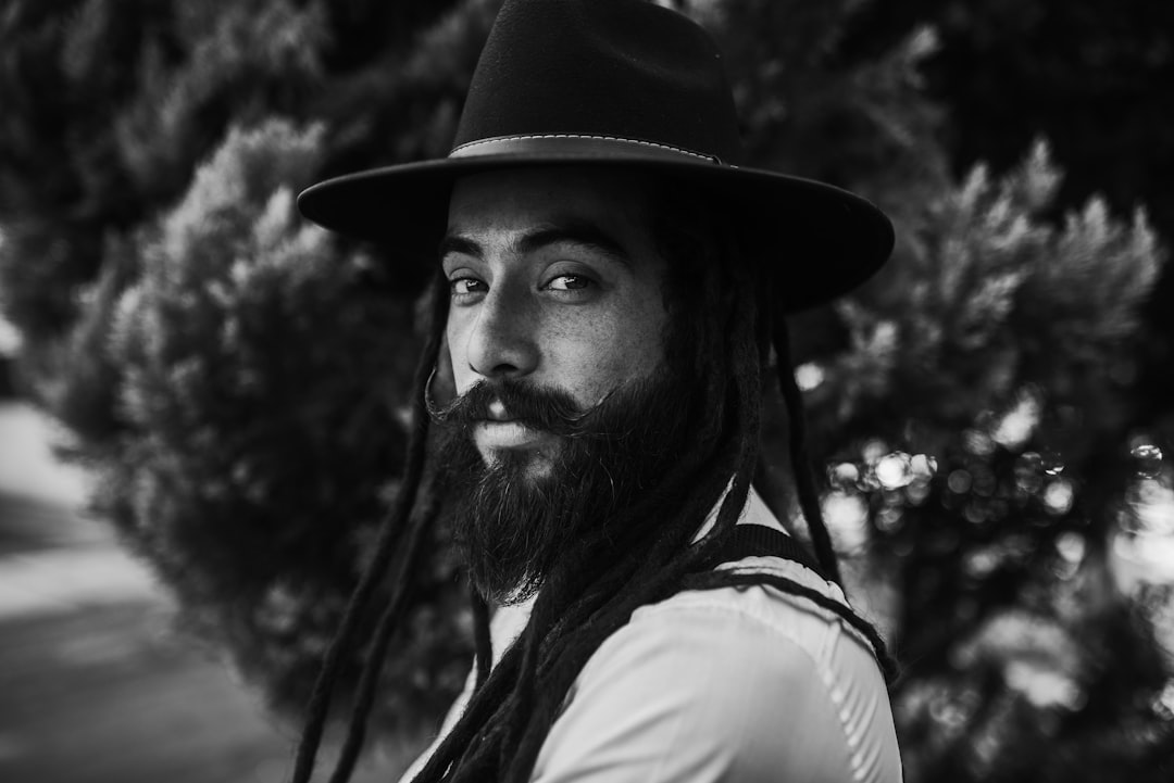 grayscale photo of man wearing black cap