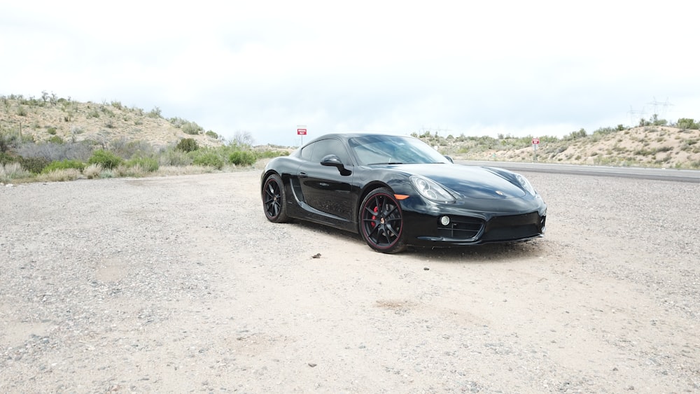 black coupe surrounding by mountain