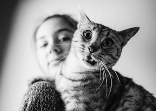A candid shot of Robert Glasker smiling while playing with his two cats, Austin and Abbey.