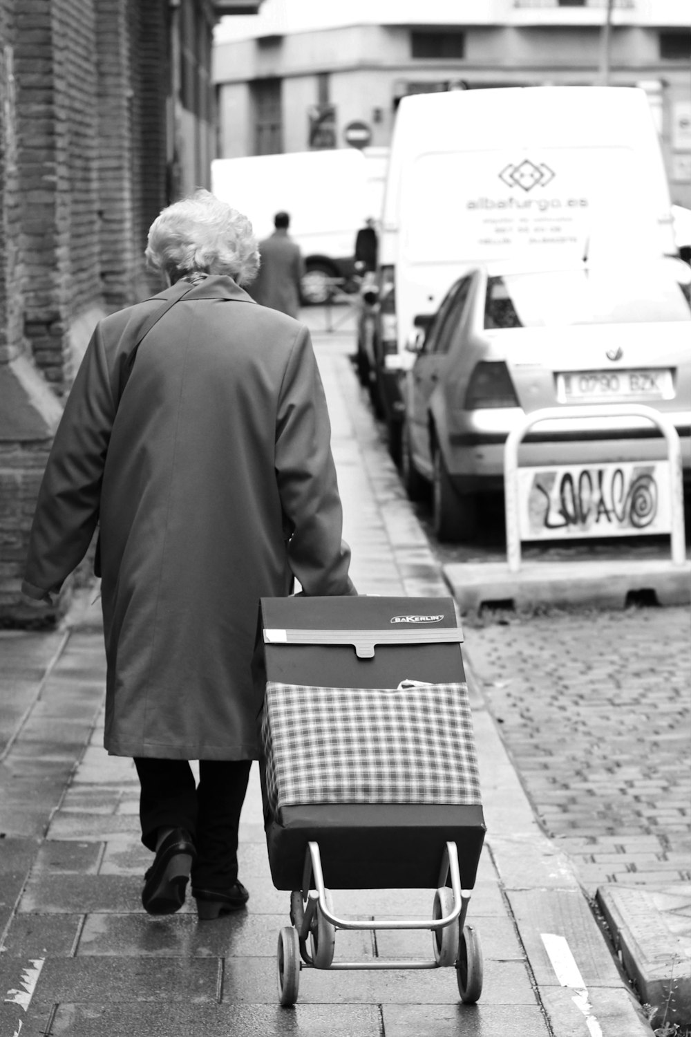 person holding stroller beside road