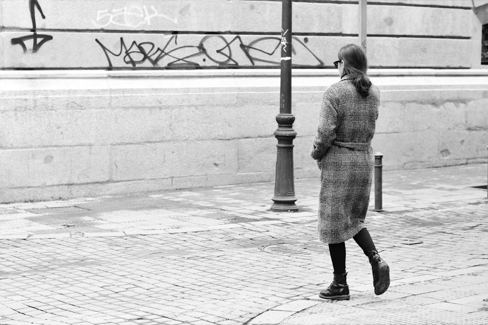 woman walking near black metal pole