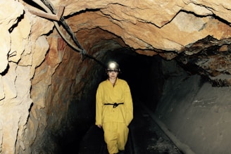 woman wearing yellow overall standing under cave