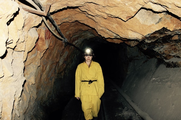 woman wearing yellow overall standing under cave