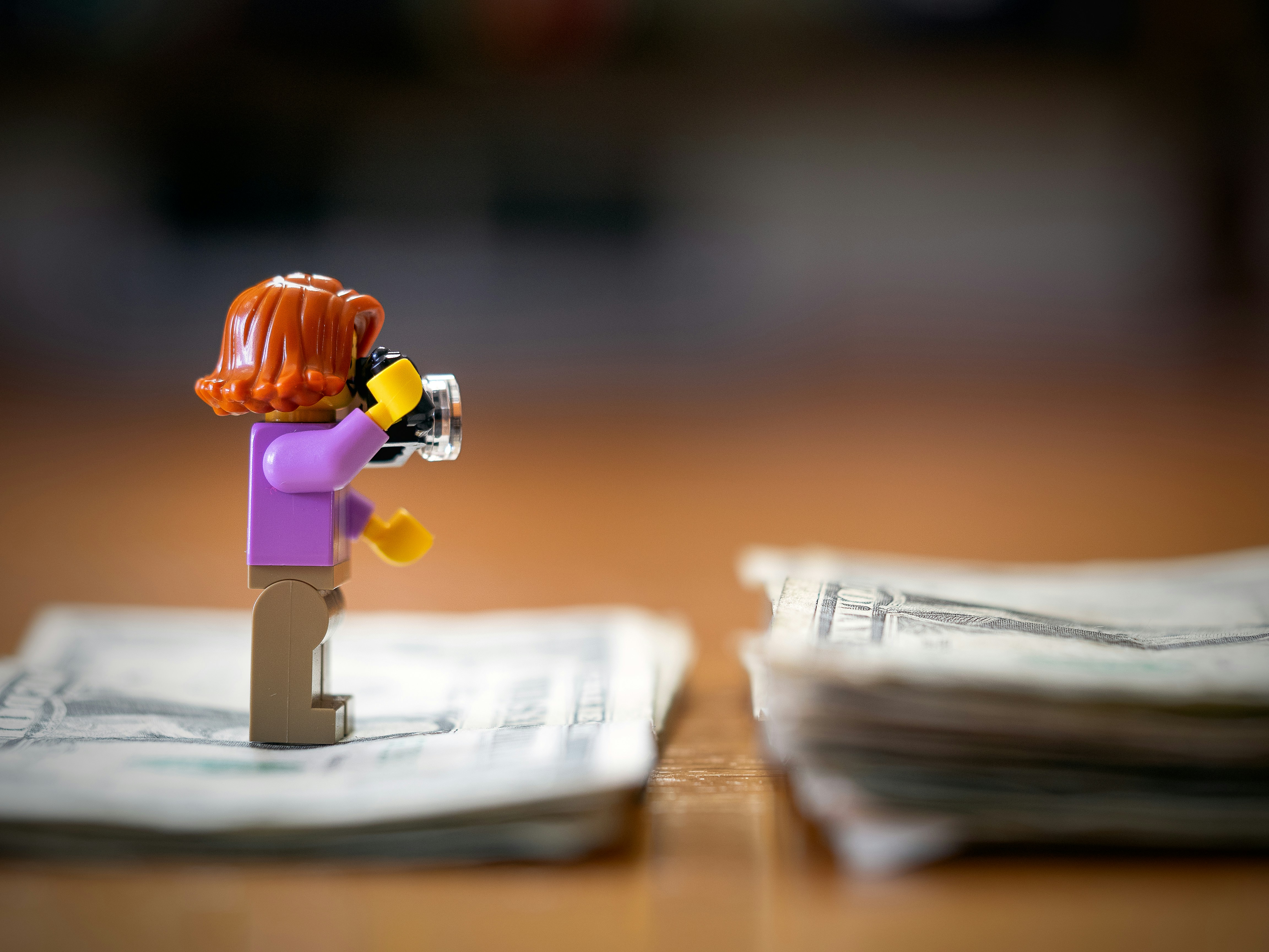 Juguete LEGO de pie sobre un billete de dólar