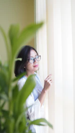 A thoughtful professional woman looking out a window, reflecting on her career choices.