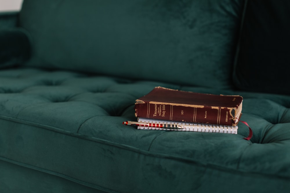 brown book on green tufted suede sofa