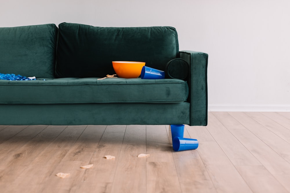 round orange plastic bowl on green sofa