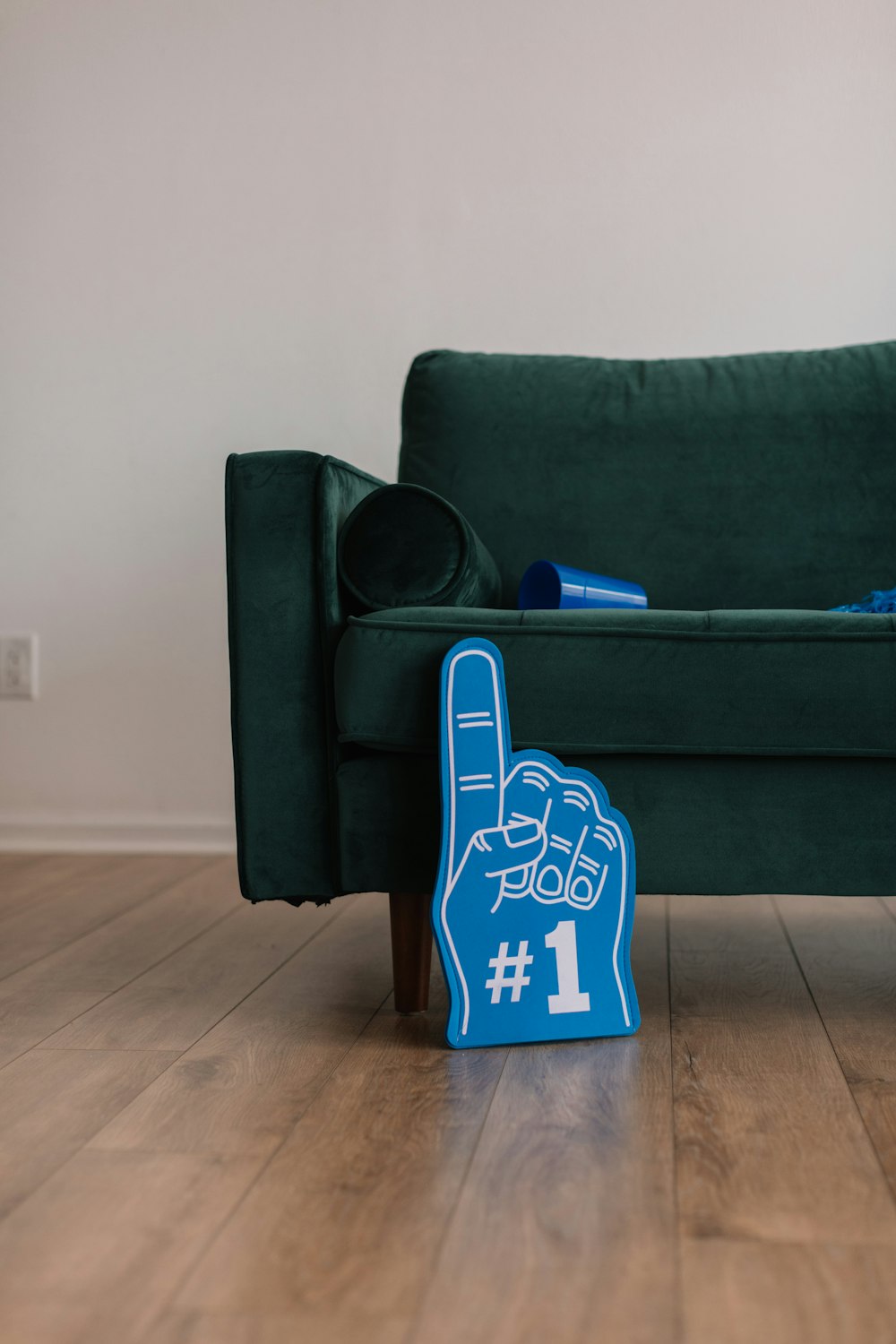 緑のソファの横にある青い#1指のサイン