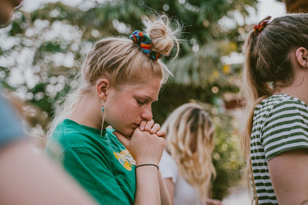 woman in green shirt closing eyes