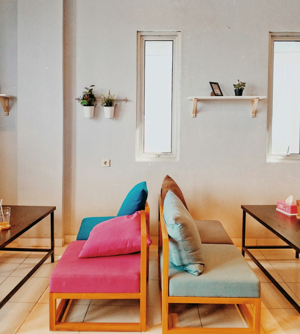 two brown wooden multicolored padded chairs near coffee tables