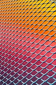 Realistic image of freshly made orange and gray chain link fences stacked neatly.